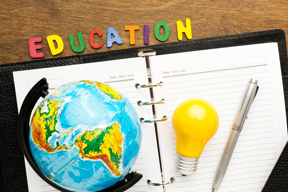 Globe, notebook and light bulb beneath the word Education