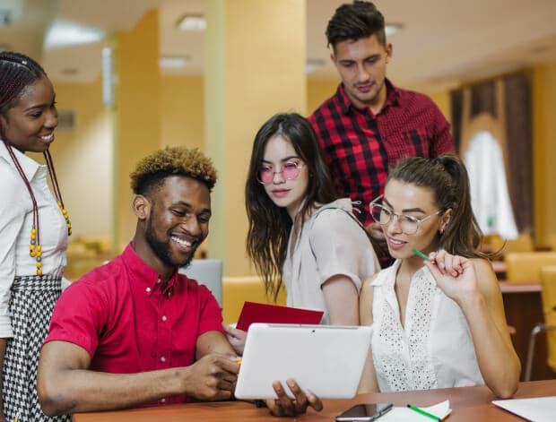 A group of students looking at a tablet together